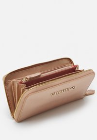 Portefeuille en cuir Valentino de couleur rose clair avec fermeture éclair dorée et logo en relief, présentant plusieurs compartiments et une finition texturée.