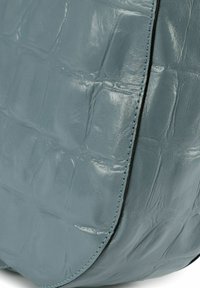 Borsa in pelle blu testurizzata con finitura lucida, caratterizzata da un motivo a stampa coccodrillo e cuciture a contrasto lungo i bordi.