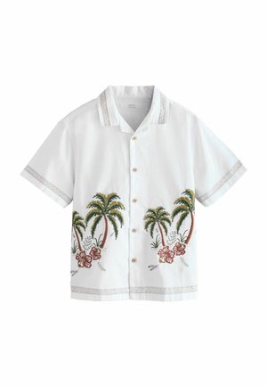 Camicia bianca a maniche corte con ricamo di palma e fiore di ibisco, bottoni in legno e dettagli a motivo sul colletto e sulle maniche.