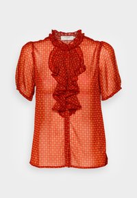 Blusa rossa trasparente con un davanti a volant e maniche a sbuffo corte. Presenta una chiusura con bottoni e un motivo a rombi.