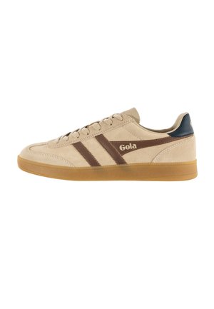 Beige suède sneaker met bruine strepen, "Gola"-logo aan de zijkant, donkerblauwe hielkap en een zool van gumrubber, gezien vanaf de buitenkant.