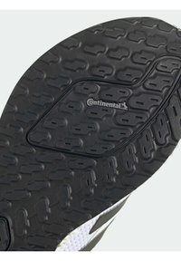 Gros plan sur la semelle noire de la chaussure avec le logo Continental et un motif de bande de roulement texturé pour une meilleure adhérence.