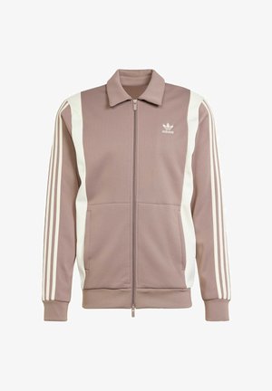 Licht mauve ritsjack gemaakt van gestructureerde stof, met witte zijpanelen en drie witte strepen op elke mouw, voorzien van een kraag en logo.