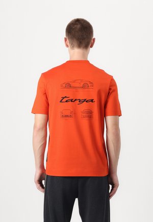 Orange kortærmet T-shirt med sorte grafiske illustrationer af biler og "targa" tekst på ryggen. Lavet af et glat, let stof.