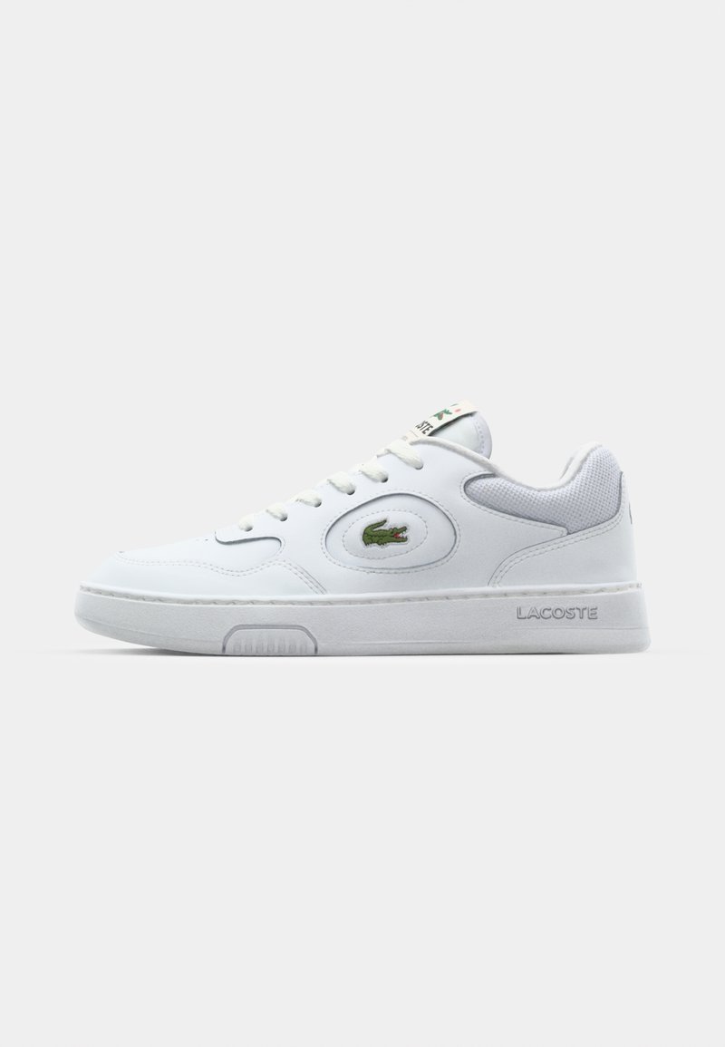 Witte sportschoenen met synthetische bovenkant, ronde neus, gevoerde kraag, veterluiting, groen logo aan de zijkant en een gestructureerde rubberen zool.