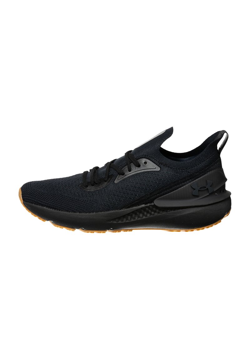 Scarpa sportiva nera con tomaia in maglia, dettagli neri e suola in gomma testurizzata. Presenta lacci e una linguetta sul retro per facilitare l'indossatura.