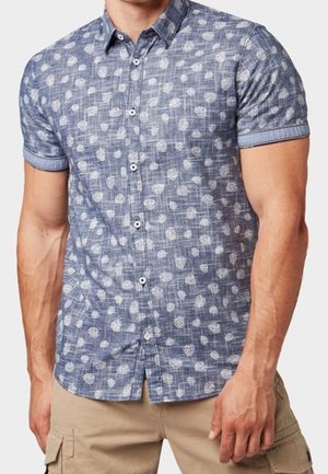 Camisa de botones de manga corta en azul con un patrón texturizado de formas blancas. Presenta un cuello clásico y mangas enrolladas.