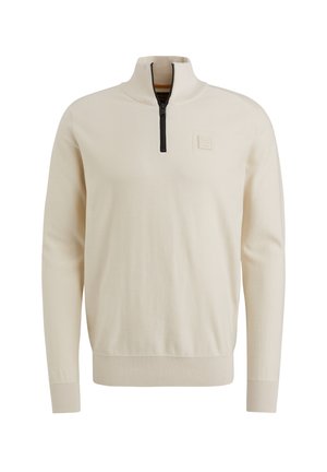 Pull-over beige clair avec col montant, fermeture éclair demi-longue à l'avant, poignets côtelés et une petite étiquette logo sur la poitrine.