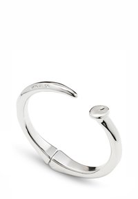 Bracelet manchette en argent avec une forme incurvée, terminé par une extrémité arrondie et une surface lisse et polie. Marques visibles sur la face intérieure.