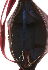 Interiér kabelky přes rameno z hnědé kůže a vzorovaného plátna, s kapsou na zip, klipem na klíče a hladkou námořnicky modrou podšívkou.