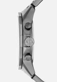 Roostevabast terasest kell ümmarguse korpusega. Omab nupulehonud ja graveeritud logo kroonil. Hõbedase tooni viimistlus ja elegantne disain.