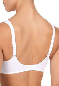 Reggiseno bianco con spalline regolabili, caratterizzato da una texture di tessuto liscia. La parte posteriore presenta una chiusura a gancio e un design minimalista senza ornamenti.