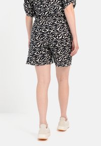 Sort og creme mønstrede shorts med elastisk talje, prydet med blomstermønster. Sæt sammen med lyse, afslappede sneakers.