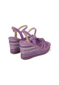 Sandali wedge viola con tomaia in suede annodata, design a doppia fascia e suola in stile espadrilles decorata con accenti metallici e testurizzati.