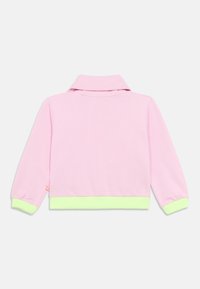 Ροζ φούτερ με γιακά, νέον πράσινο ριμπ τελείωμα στη μέση και στις μανσέτες, μακριά μανίκια και άνετη εφαρμογή. Λείο ύφασμα.