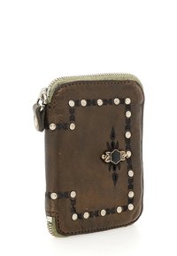 Portafoglio in pelle marrone con borchie argentate, cuciture decorative nere e un motivo floreale. Presenta una chiusura a zip e una forma rettangolare compatta.