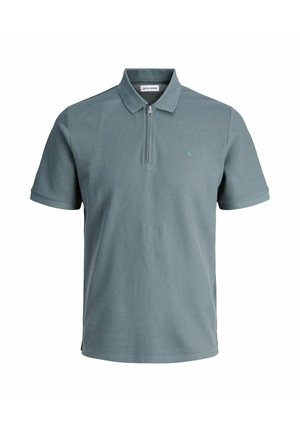 Világos türkiz színű pólóing, texturált anyagból készült, fél cipzáras, rövid ujjú, és egy apró hímzett logóval rendelkezik a mellrészen.