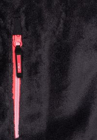 Melnā flīsa jaka ar rozā rāvējslēdzēju un melnu vilkšanas cilpu. Tekstūrēta, mīksta auduma ar pūkainu izskatu. Kompakts dizains.