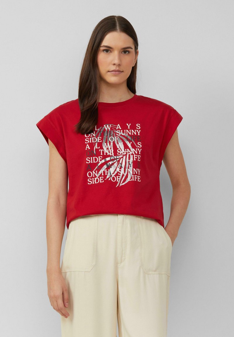 Rode katoenen T-shirt met korte opgerolde mouwen, met een wit grafisch tekstontwerp waarin de zin "Altijd aan de zonnige kant van het leven" is opgenomen.