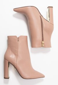 Różowe skórzane botki za kostkę z szpiczastymi noskami, złotymi bocznymi zamkami i kwadratowymi obcasami z złotymi detalami. Gładka faktura i dopasowany krój.
