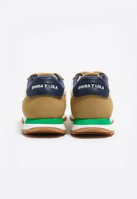 Zapatillas de ante y cuero en tonos marrón, marino y blanco, con una suela verde y blanca, y la marca "BIMBA Y LOLA" en los talones.