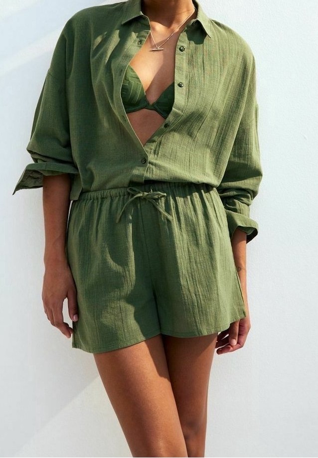 Camisa de lino verde oliva con mangas enrolladas, cuello abierto y pantalones cortos con cordón. El conjunto cuenta con un tejido texturizado y un corte relajado.