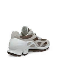 Kraftiga atletiska sneakers med en beige och brun färgskala, tillverkade av mesh och mocka, med en strukturerad gummisula och förstärkt hälstöd.