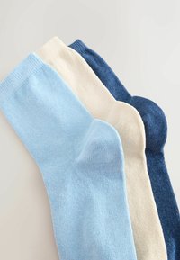 Trys porų kojinių šviesiai mėlyna, kreminės ir tamsiai mėlynos spalvos. Pagamintos iš švelnaus, tekstūruoto audinio su banguotu kraštu ir lygia apdaila.