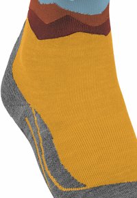 Calzino multicolore con motivi sovrapposti in giallo, grigio e blu. Realizzato in materiale liscio e elastico con accenti testurizzati.