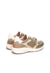 Baskets de sport présentant un mélange de cuir beige, vert olive et blanc. Semelle blanche épaisse avec des accents marron et des détails texturés sur les côtés.