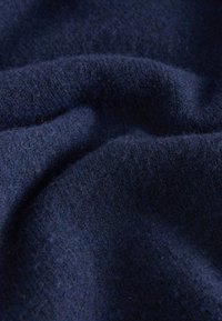 Granatowy materiał o miękkiej, teksturowanej powierzchni, charakteryzujący się lekko puszystym wyglądem i subtelnymi różnicami w splocie.