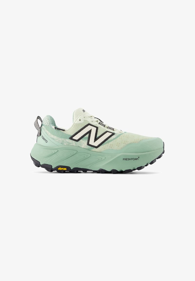 Trail running shoe in light mint green mesh and synthetic upper, featuring a prominent black “N” logo, padded collar, and rugged black outsole.