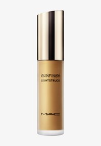 MAC Skinfinish Lightstruck dans un élégant flacon doré avec un capuchon courbé réfléchissant et un texte noir sur fond mat.