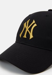 Schwarze Kappe mit einem gebogenen Schirm, auf der Vorderseite mit einem auffällig gestickten goldenen 'NY'-Logo versehen. Hergestellt aus glattem Stoff mit einer strukturierten Krone.
