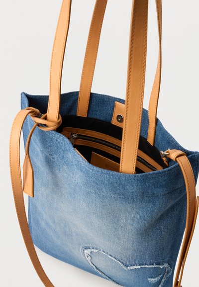 Τσάντα ώμου από τζιν με λουριά από καφέ δέρμα και εσωτερική τσέπη με φερμουάρ, με καρδιά ραμμένη στο μπροστινό μέρος.