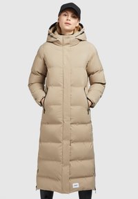 Beige polstret lang frakke med hætte, lynlåslommer på siden og sorte detaljer. Glat tekstur, knælængde design, og logo mærke ved kanten.