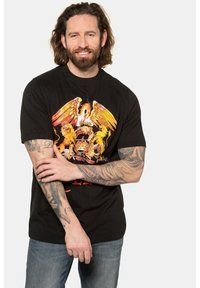 Sort bomulds T-shirt med en farverig grafik af en kronet ørner og løver, med rød tekst under designet, afslappet pasform.