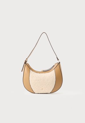Sac à épaule tan avec une poignée courbée, présentant un panneau avant texturé en laine crème et des accents en métal doré.