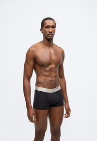 Fekete boxeralsó világosszürke elasztikus derékpánttal, amelyen a "DIESEL" felirat található. Simább anyagból készült, testhez simuló kialakítással.