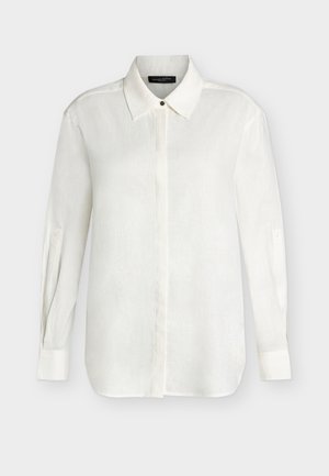 Λευκό πουκάμισο με μακριά μανίκια, κουμπιά κρυμμένα μπροστά και μυτερό γιακά, απλωμένο σε ανοιχτόχρωμο φόντο.