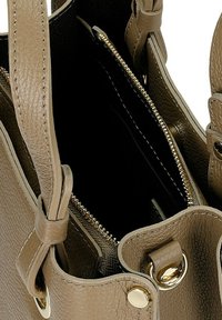 taupe Lederhandtasche mit goldenen Beschlägen, einschließlich eines Reißverschlusses und runden Akzenten, ausgestattet mit einer Innentasche und strukturiertem Finish.