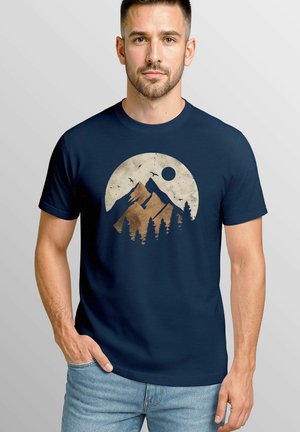 Navy t-shirt featuring a circular design with mountains, trees, birds, and a sun, in earthy tones of brown and cream.