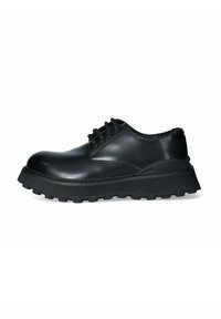 Scarpa in pelle nera con allacciatura, punta tonda, suola in gomma spessa e testurizzata, e dettagli di cucitura sulla parte superiore, dotata di sei occhielli.