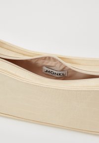 Kerman faux nahasta laukku, jossa on krokotiilikuosi, vetoketjusuljenta ja sileä vuorattu sisustus, jossa on "MONK"-tunnus.