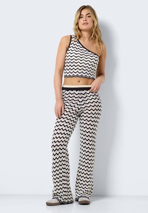 Haut court à motif zigzag noir et blanc et pantalon évasé, fabriqués en tissu tricot léger, avec un design à une épaule et une taille élastique.