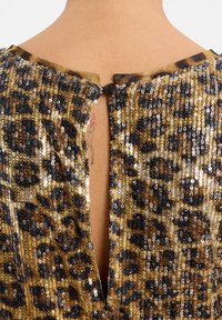 Robe à imprimé léopard ornée de sequins dorés et noirs, avec un design à dos en trou de clé et une fermeture à un seul bouton noir à la nuque.