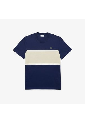 Granatowa koszulka z krótkim rękawem, z poziomym kremowym paskiem. Okrągły dekolt, wykonana z bawełny, z małym zielonym logo na piersi.