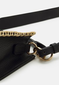 Borsa a mano in pelle nera con bordi intrecciati in color nocciola, hardware in tonalità dorata, superficie texturizzata e tracolla staccabile con attacco a forma di anello.