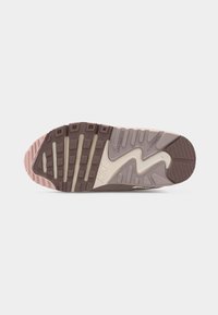 Σόλα αθλητικού παπουτσιού Nike με πολύ-υφασμικό πέλμα σε μπεζ, καφέ και ροζ, που δείχνει αύλακες για μη επισήμανση και ευκαμψία σε λευκό φόντο.