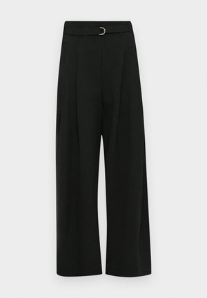 Schwarze weite Hosen aus einem glatten Stoff, mit einem Gürtel mit einer silbernen Schnalle, Falten an der Vorderseite und einem geraden Saum.